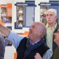 Community members laugh while enjoying the exhibit